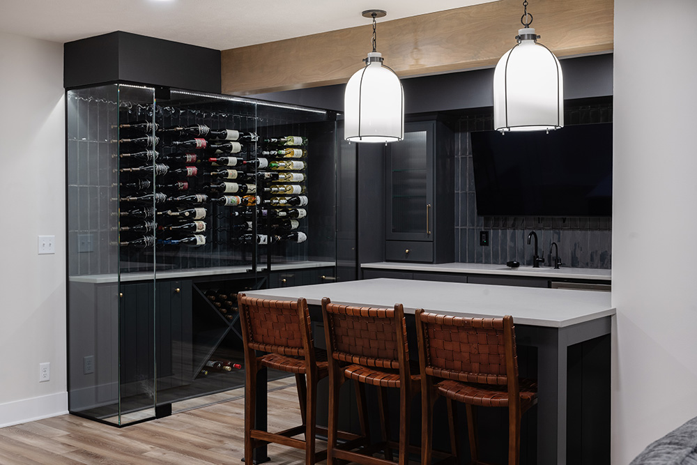 Omaha Home, Kitchen, Bathroom and Basement Remodeling - A modern kitchen featuring a glass-enclosed wine cellar, sleek countertops, and stylish bar stools awaits a night of culinary adventure.