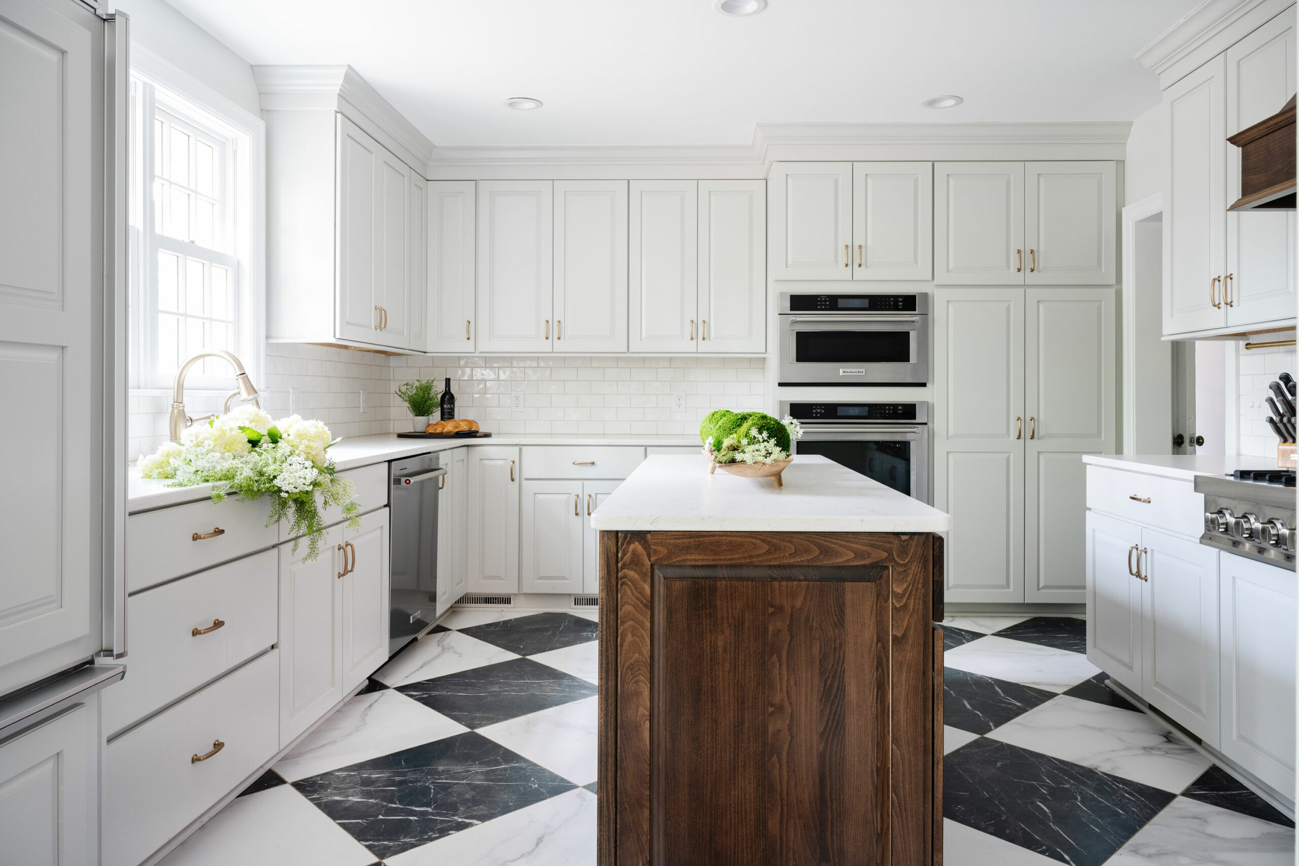 Omaha Home, Kitchen, Bathroom and Basement Remodeling - Bright and elegant kitchen with a mix of white cabinetry, marble countertops, and a contrasting wood island.